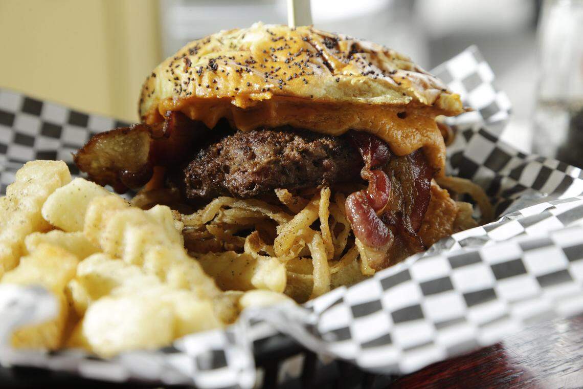The Bad Wolf Burger, made with a Cajun seasoned patty and topped with bacon, house-made beer cheese and onion straws at Bad Wolf Burgers.