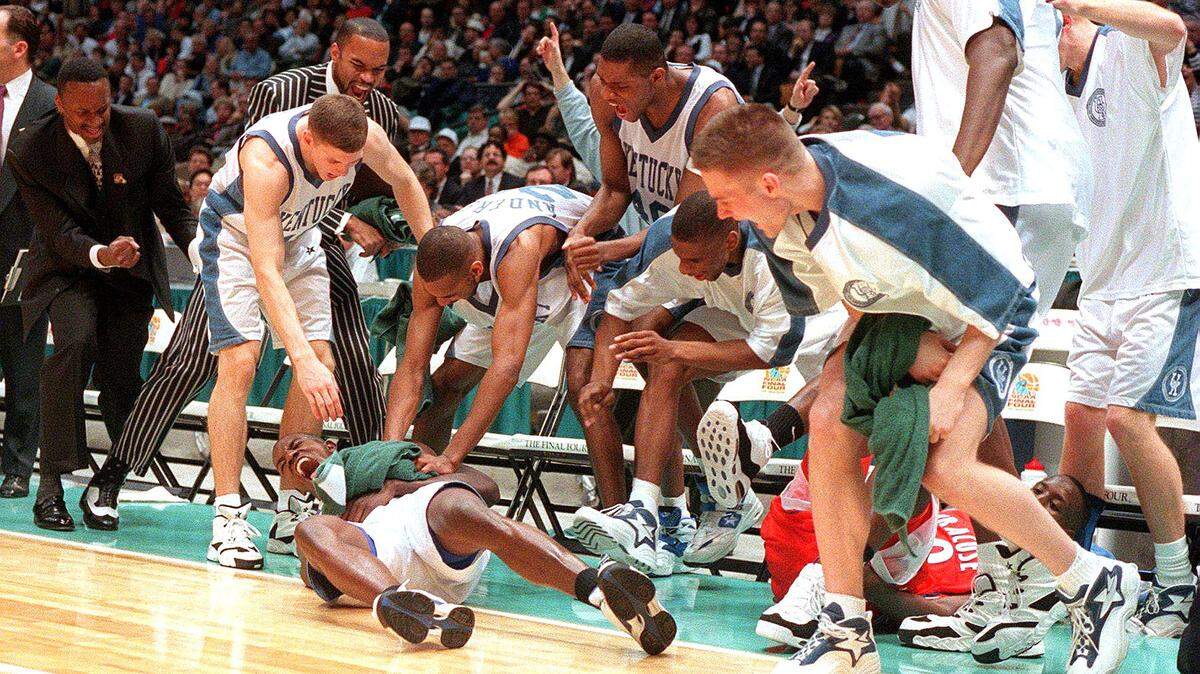 Tony Delk is mobbed by Kentucky teammates after getting fouled while hitting a three-pointer in the national title game against Syracuse in 1996.