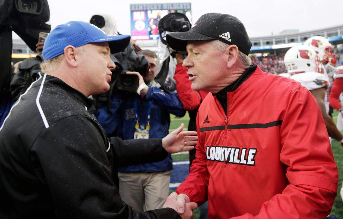 Kentucky Coach Mark Stoops, left, and Louisville Coach Bobby Petrino, right, are directing programs that currently seem headed in opposite directions. UK is 4-0 and ranked No. 17 in the country. U of L is 2-2 with an attack ranked No. 124 out of 129 FBS teams in total offense.