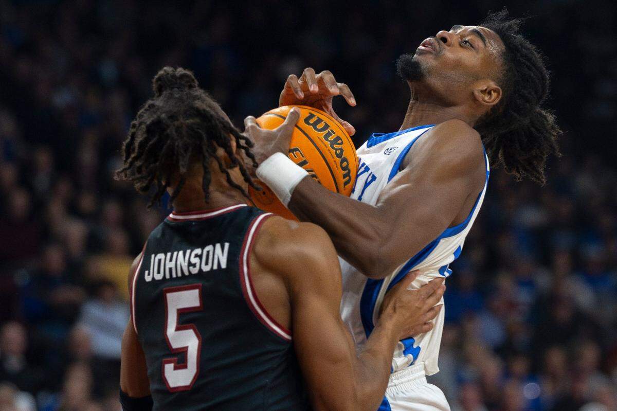 Kentucky’s Antonio Reeves (12) and South Carolina’s Meechie Johnson (5) reach for a ball during Tuesday’s game. Reeves finished with 15 points.