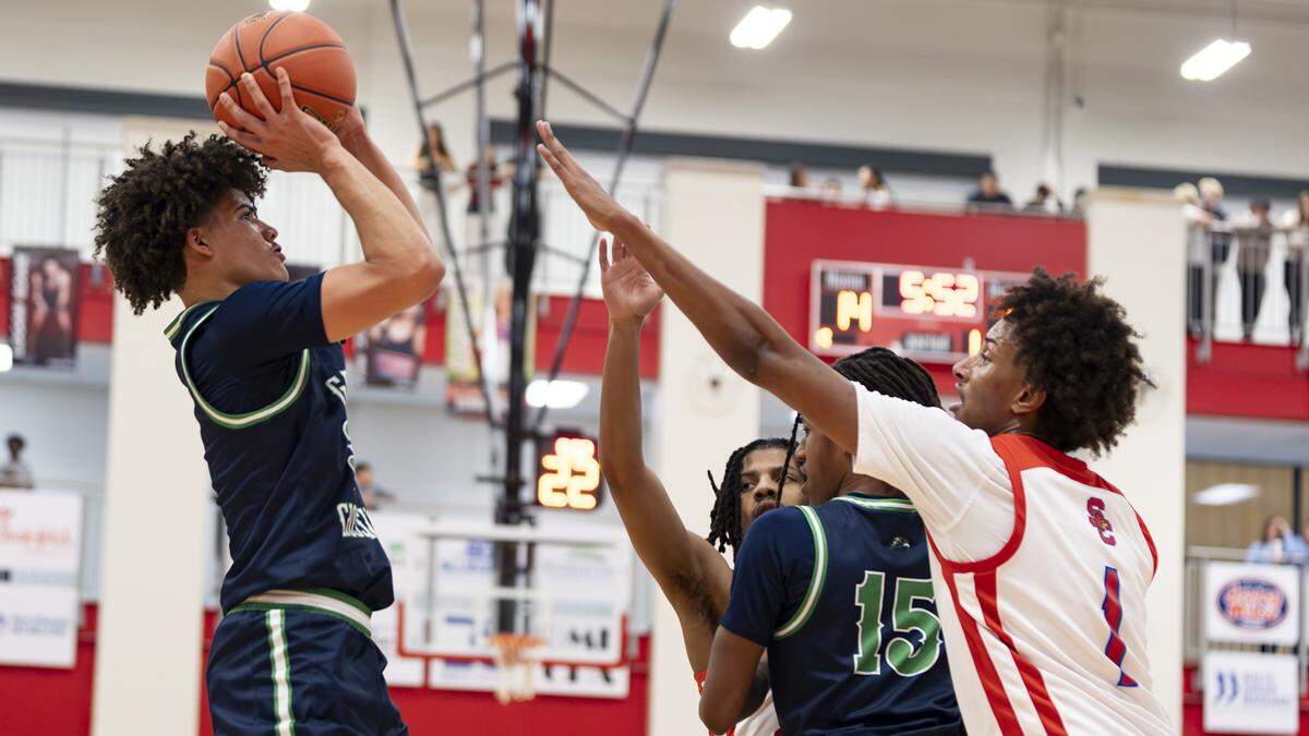 Great Crossing’s Travanti Cooper, left, went up for a baseline jumper over Scott County’s Tidiane Faye during the Warhawks’ 69-51 win at Coach Billy Hicks Gymnasium on Saturday in Georgetown.