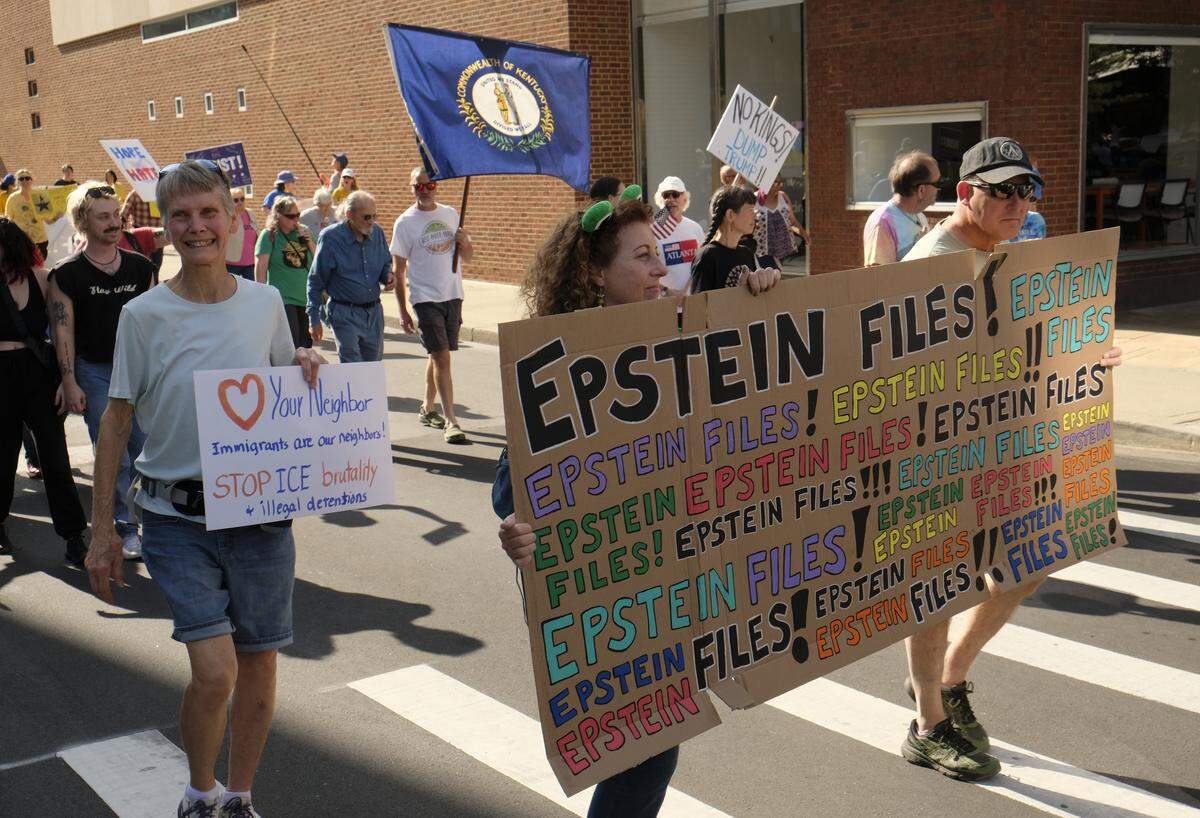 Monica Rathke, center, carried an “Epstein Files” sign at the No Kings rally in Lexington, Ky., Oct. 18, 2025.