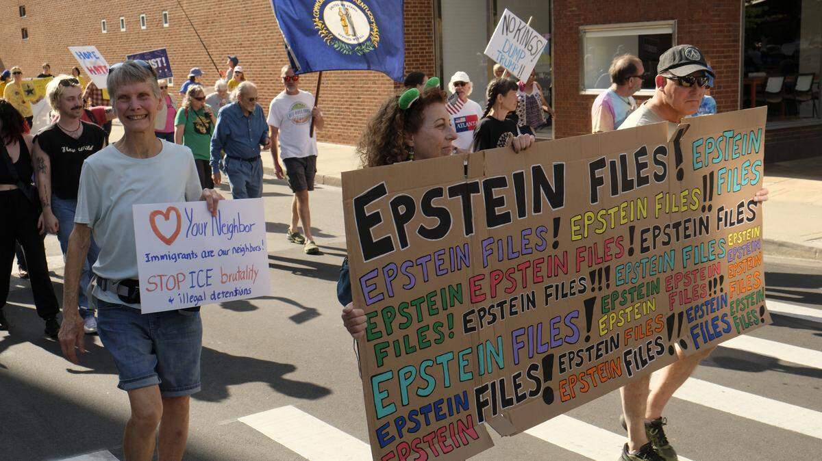 Monica Rathke, center, carried an “Epstein Files” sign at the No Kings rally in Lexington, Ky., Oct. 18, 2025.