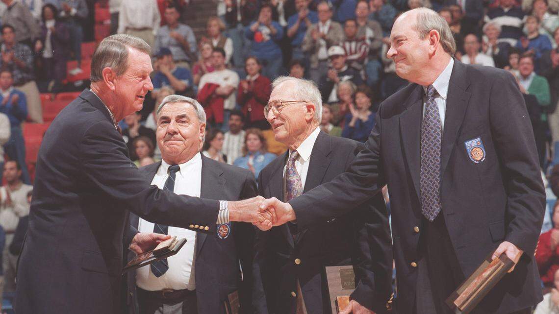 Dale Barnstable, left, and other members of the first Kentucky team to win an NCAA championship were congratulated by Adolph Rupp Jr. during halftime of a UK game against Florida in Rupp Arena on Jan. 1, 1998. Humzey Yessin (second from left), the team’s manager, and Bud Berger, the team’s trainer, also took part in the ceremony.