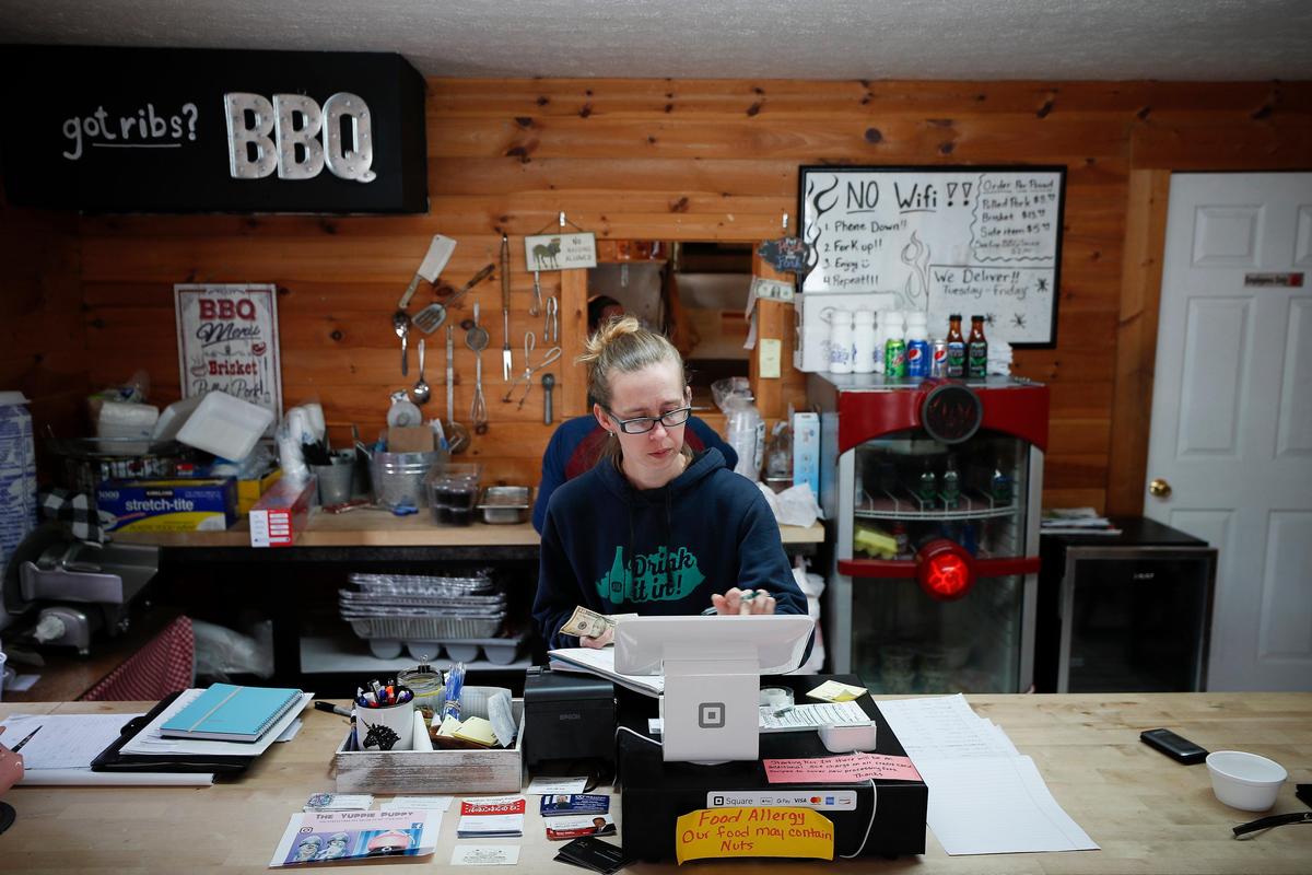 Jenny Lawhorn works the cash register Wednesday at The Grillfather. According to co-owner and chef Adam Lawhorn, business has been down significantly since the beginning of the coronavirus pandemic and the restaurant is only offering call ahead orders two days a week.