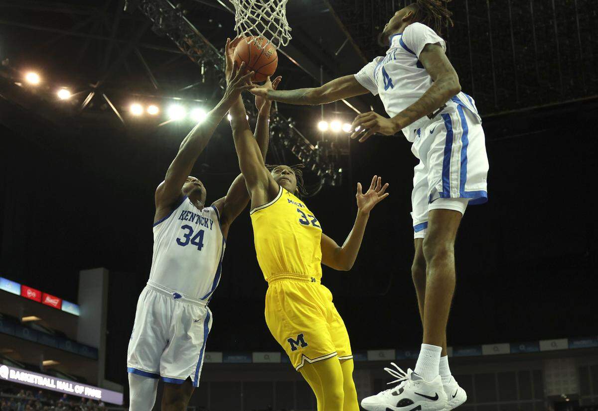Michigan’s Tarris Reed Jr. (32) goes for the basket as Kentucky’s Oscar Tshiebwe (34) and Daimion Collins (4) defend during Sunday’s game at the O2 Arena, in London, England.