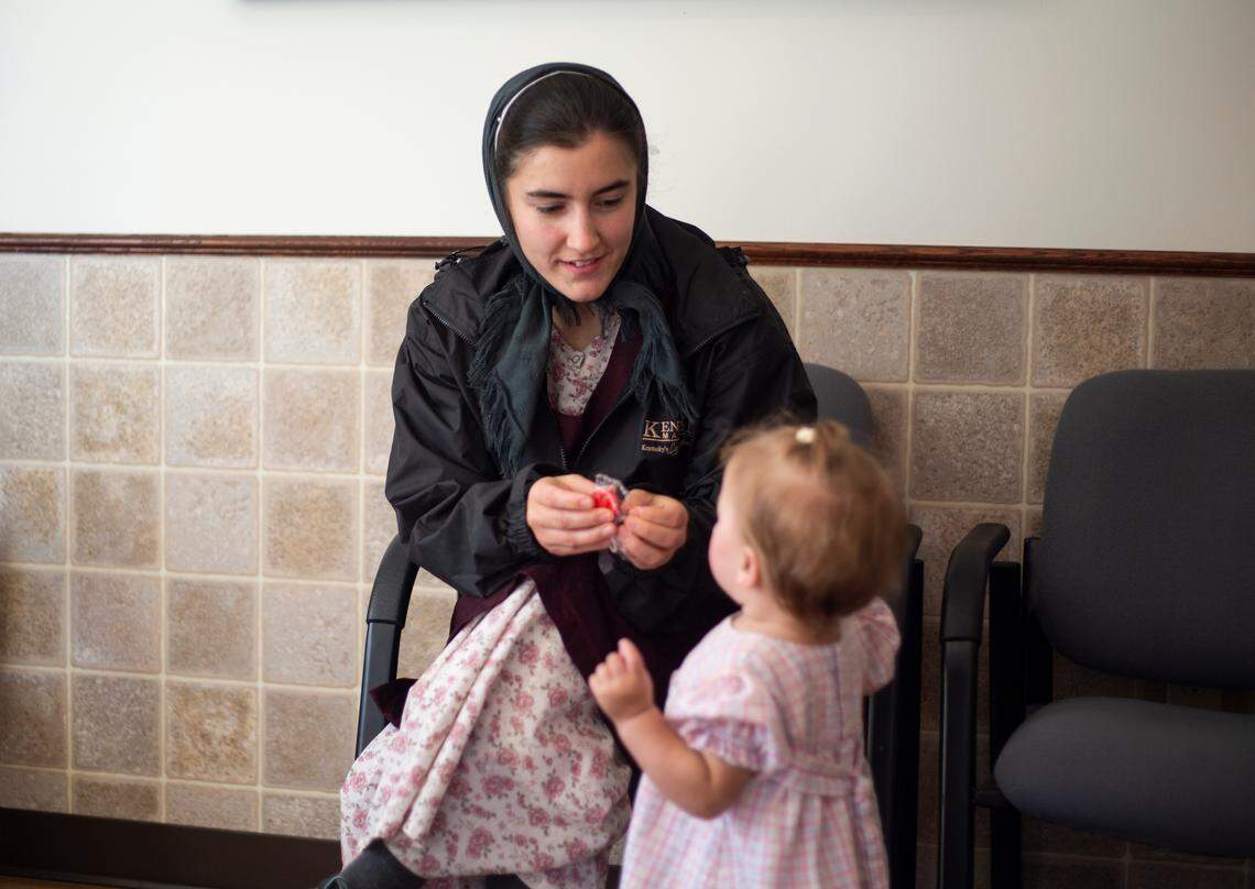 Norma Jeane Horst, 24, gives her 1-year-old daughter, Beverly, a sucker in the waiting room of the WeCare Clinic in Fairview, Kentucky, while they wait for a public health nurse to give Beverly her vaccinations.