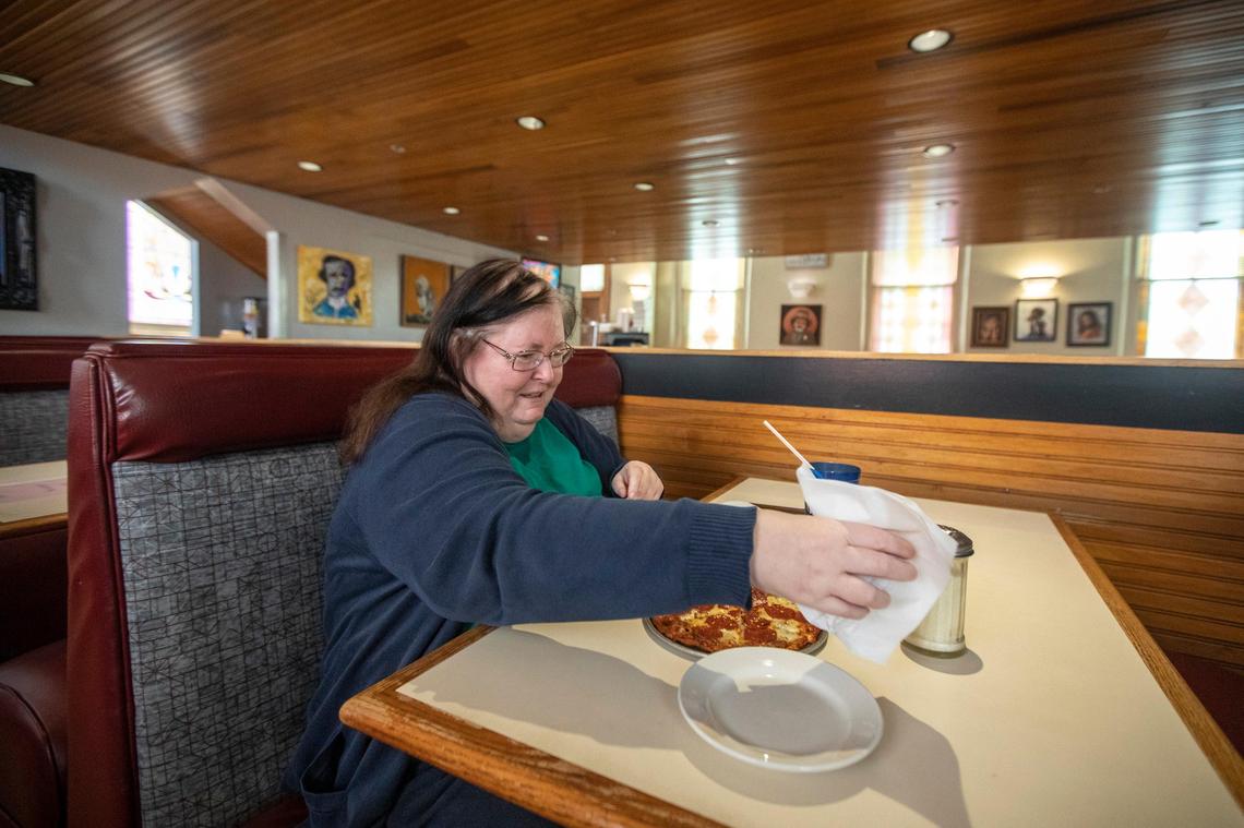Ann Parks puts chili flakes on her pizza at Joe Bologna’s May 22, the first day restaurants could reopen to dine-in customers.