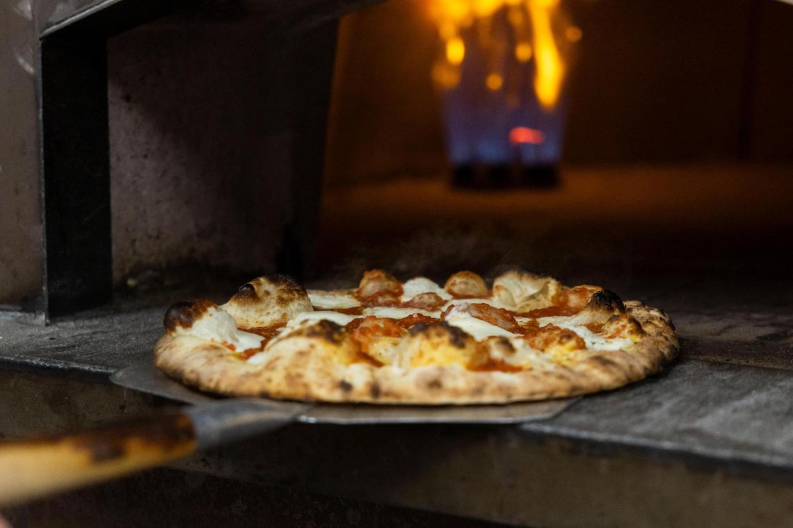 Ethereal Slice House employees prepare old world style pizza a brick style oven with temperatures near 900 degrees.