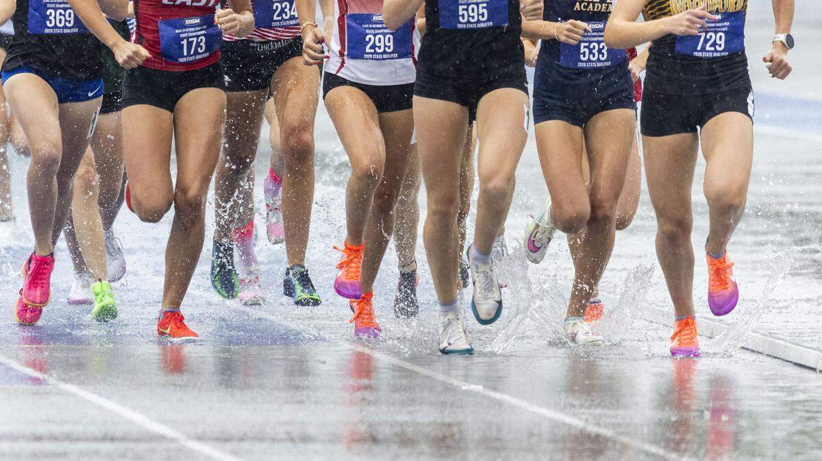 Runners make their way down the backstretch of the girls 1600 meter run in the pouring rain during the 2026 KHSAA Boys and Girls Class 3A State Track and Field Championships at the University of Kentucky track and field complex in Lexington, Ky., on Saturday, May 23, 2026.