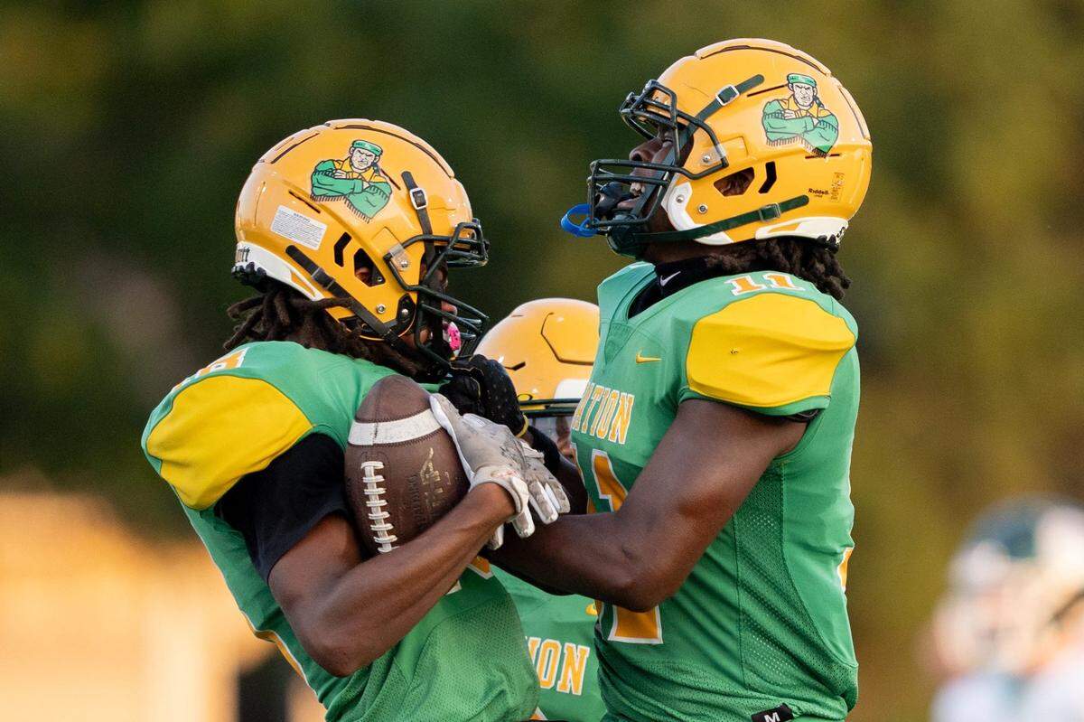 Bryan Station's Ronnik Woolfolk (18) and Taeandre Clark (11) celebrate Woolfolk's interception during their game against Trinity on Friday, Aug. 23, 2024 at Bryan Station High School in Lexington, Ky.