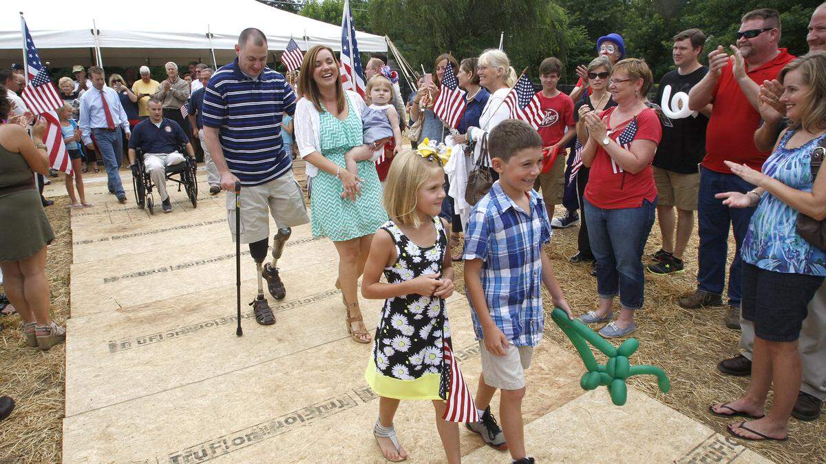U.S. Marine Cpl. Matt Bradford and his wife, Amanda, holding Layla, followed Emma and Nolan Leff to check out their new home in Equestrian Estates in Jessamine County on Saturday. The Helping a Hero program built the customized house for the family. Matt Bradford lost his legs and eyesight in Iraq in 2007.