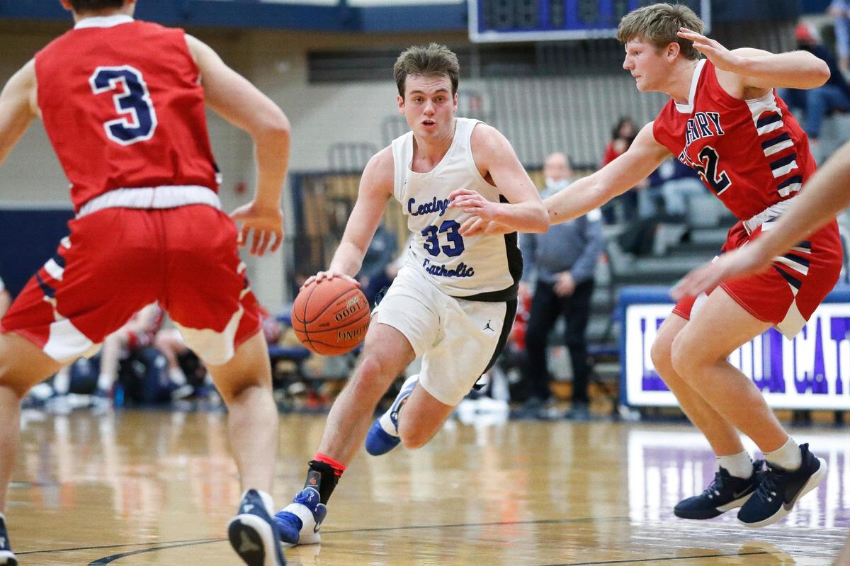 Lexington Catholic’s Ben Johnson (33) dribbled between St. Henry’s Cory Shea (3) and St. Henry’s Jude Bessler (22) Thursday night. Johnson scored 31 points.