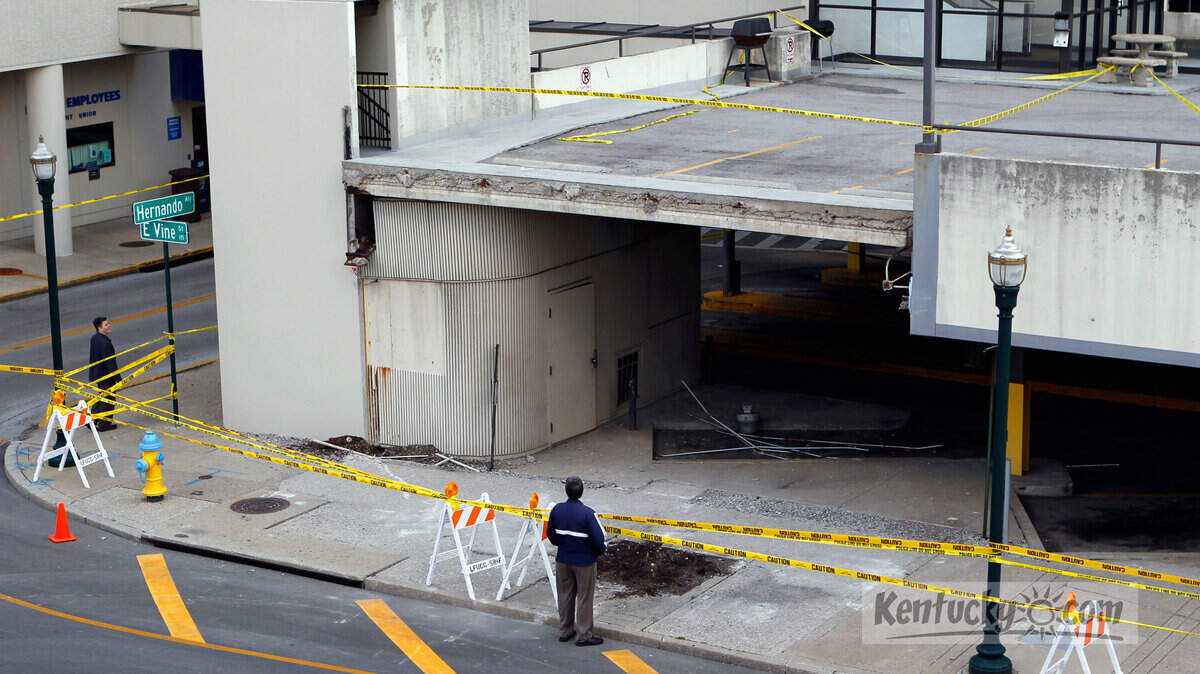 People looked Monday at the damage to the Phoenix parking garage after a 28-foot-long concrete panel fell off the side Sunday at the city-owned garage on East Vine Street in Lexington. No one was hurt as the panel fell from the second level and crashed onto the sidewalk across from the Lexington Transit Center. On Sunday, Tom Wilson, the city's parking garage manager said, "Under no circumstances will we open this garage until it is safe". The garage has 150 parking spaces.
