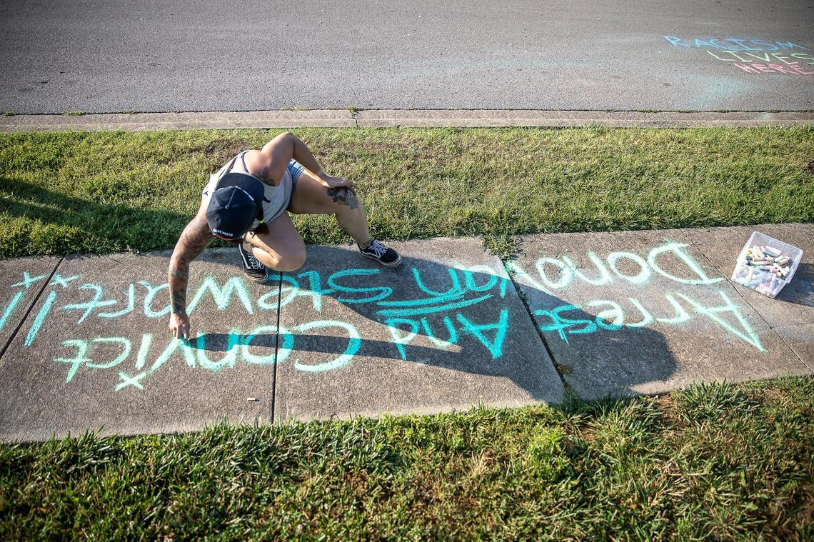 Liane Woodhead, of Lexington, wrote “arrest and convict Donovan Stewart” in chalk outside the Fraternal Order of Police Bluegrass Lodge 4 in Lexington Thursday.