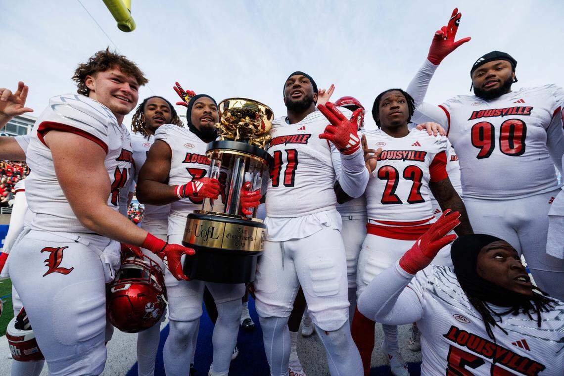 Louisville football players Ramon Puryear (41) and Jathan Hatch (31) held up the Governor’s Cup trophy after the Cardinals claimed it for the first time since 2017 by defeating Kentucky 41-14 last season at Kroger Field.