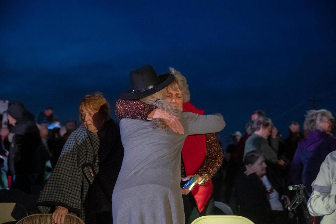Mary Ellen Matthews, left, and Diane Robbins embrace following a Christmas Eve service with members of Mayfield First Presbyterian Church and Mayfield First Christian Church in an empty lot between their destroyed church buildings.