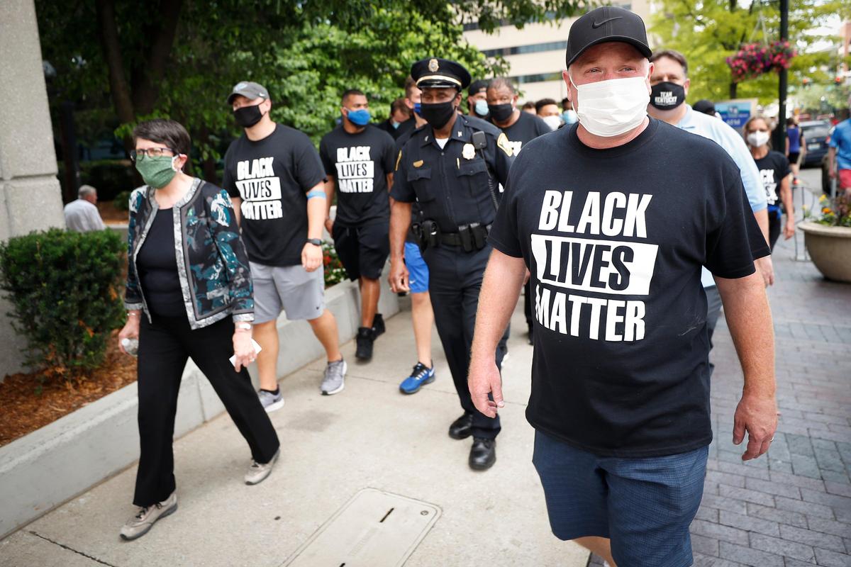 University of Kentucky head football coach Mark Stoops, right, walked with Lexington Mayor Linda Gorton, Lexington Police Chief Lawrence Weathers, and players during a march supporting Black Lives Matter on Friday.
