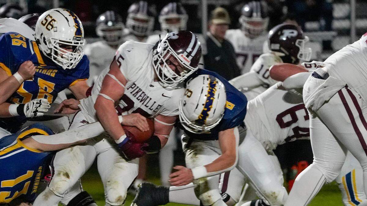 Harrison Phillips (8) and the Sayre defense bring down Pikeville’s Isaiah Hurt (25). “This was a game where we had to show who we were other than the high-flying offense,” Sayre coach Chad Pennington said.