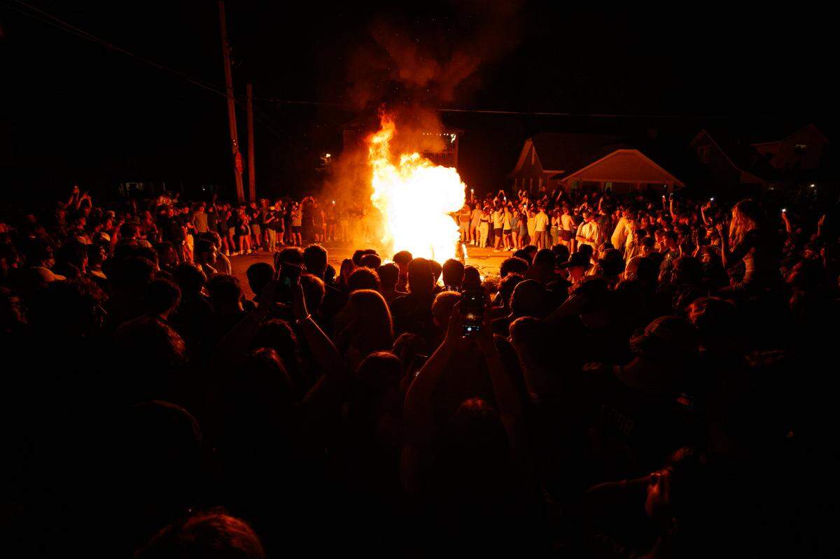 Fans crowded around a fire on State Street Saturday night after the University of Kentucky Wildcats’ football win over the Florida Gators.
