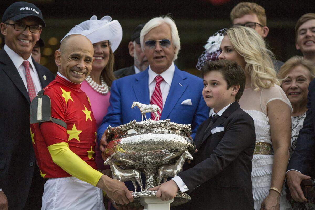 Mike Smith, the jockey who won the Belmont Stakes atop Justify, celebrated with the Belmont Stakes trophy with trainer Bob Baffert and Baffert’s son, Bode, at Belmont Park on June 9, 2018.