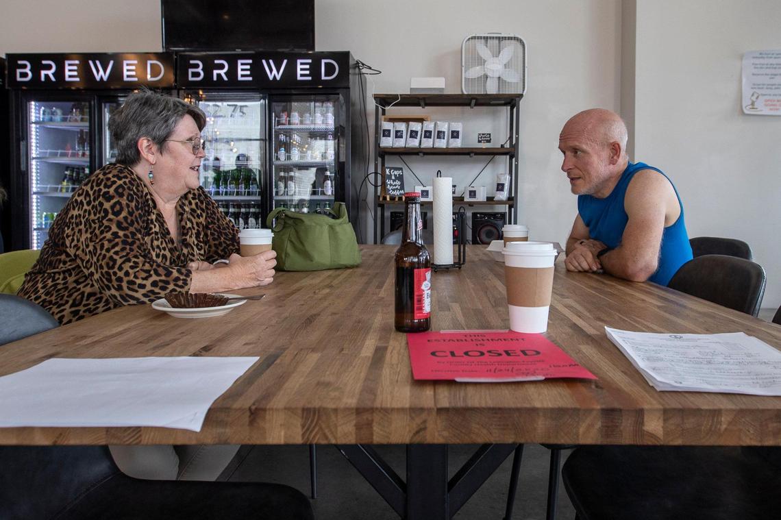Marsha Foster, of Cynthiana, and David Adams, of Nicholasville, chat at Brewed in Lexington on Tuesday. A notice from the Lexington-Fayette County Health Department ordering the establishment closed sits on the table.