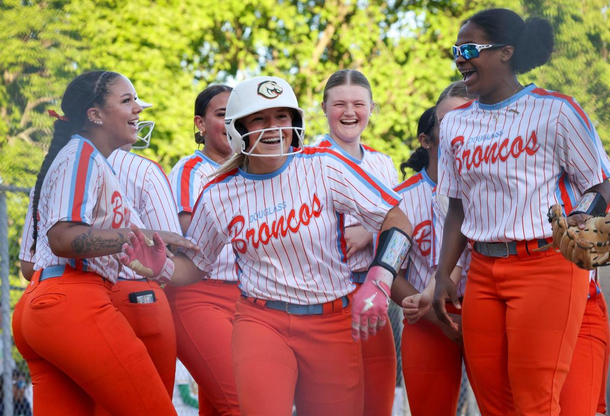 Frederick Douglass pitcher Savannah Wombles, center, celebrates her go-ahead home run with teammates after she crossed the plate in the seventh inning Friday.