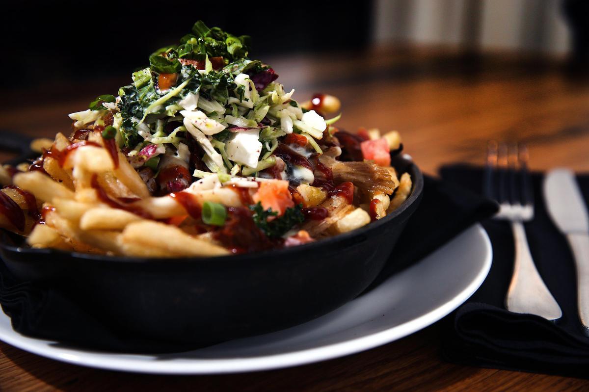 Carolina Fries with smoked pork shoulder, kale slaw, queso blanco and barbecue sauce over fries at Graze at 111 Woodland Avenue.