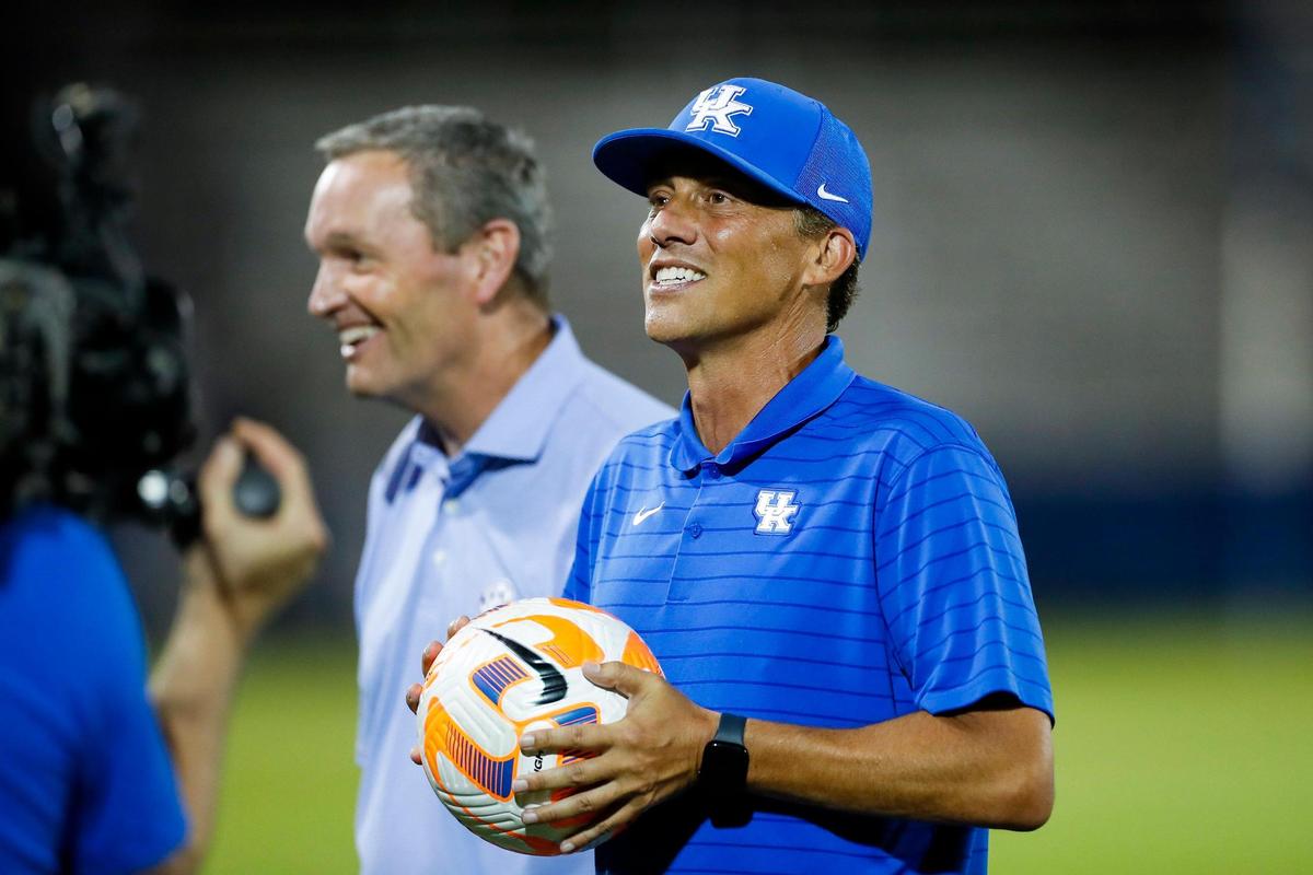 Kentucky Athletics Director Mitch Barnhart, left, presented the game ball to new women’s soccer head coach Troy Fabiano after UK’s 3-0 season-opening win over Ball State on Thursday night in Lexington.