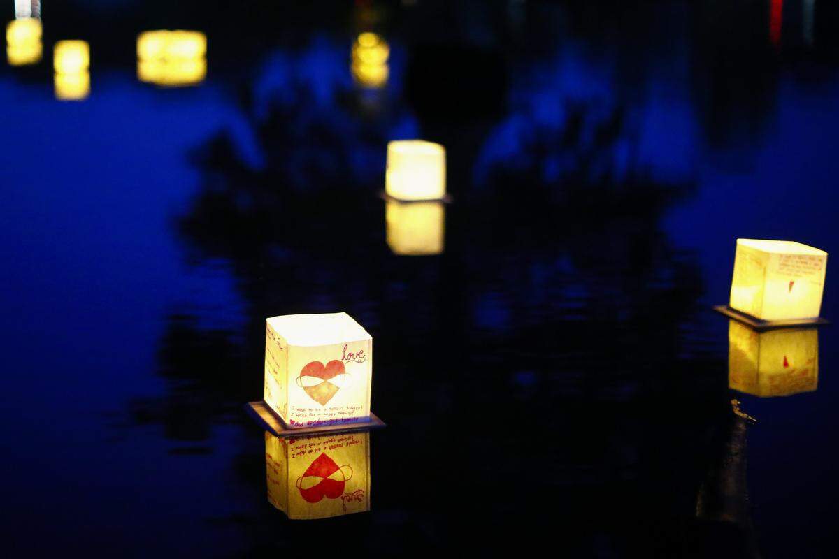 Lit lanterns float on the lake during the Water Lantern Festival at Jacobson Park in Lexington, Ky., Saturday, June 22, 2019. The Water Lantern Festival tours multiple cities throughout the year and donates all proceeds to charity.