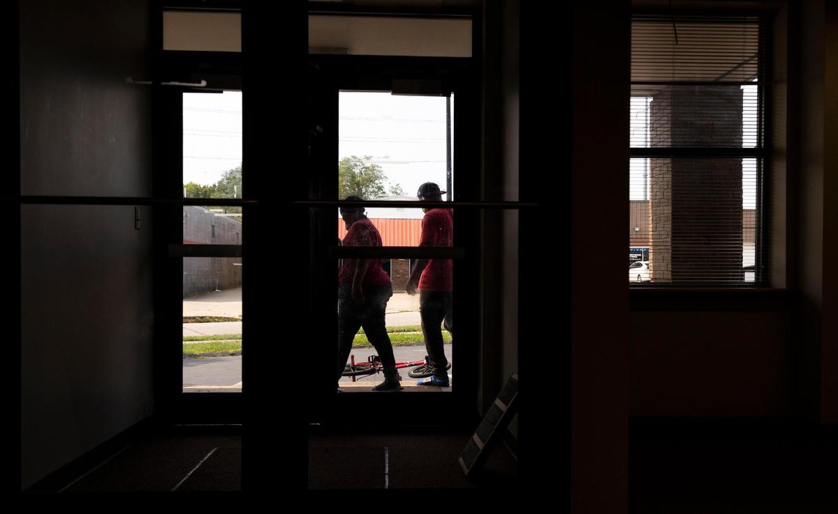 People stand outside the location of the new Catholic Action Center expansion that plans to add 80 beds because of an increase in need for shelter beds due to the upcoming cold winter weather and COVID-19 in Lexington, Ky., Wednesday, September 9, 2020.