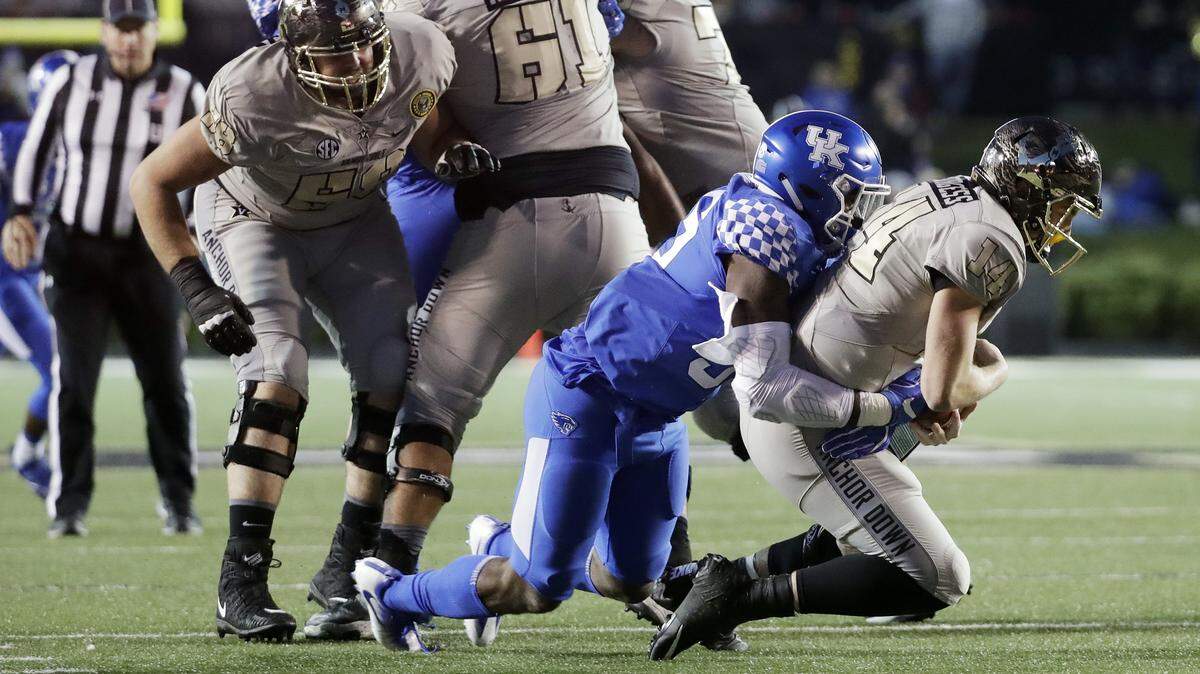 Vanderbilt quarterback Kyle Shurmur (14) was sacked by now-former Kentucky defensive end Denzil Ware (35) in UK’s 44-21 victory over the Commodores last season in Nashville.