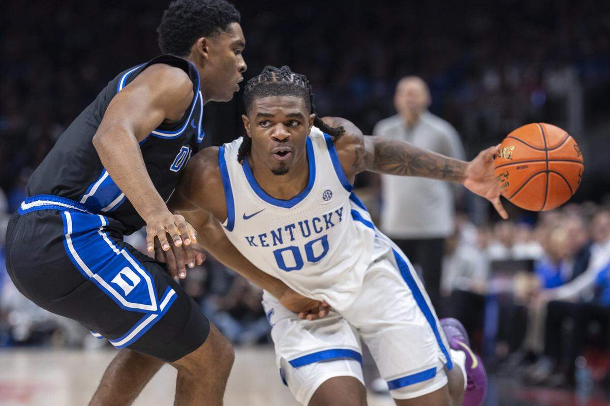 Kentucky guard Otega Oweh (00) drives the ball as Duke guard Caleb Foster (1) defends during Tuesday’s game in the Champions Classic at State Farm Arena in Atlanta.