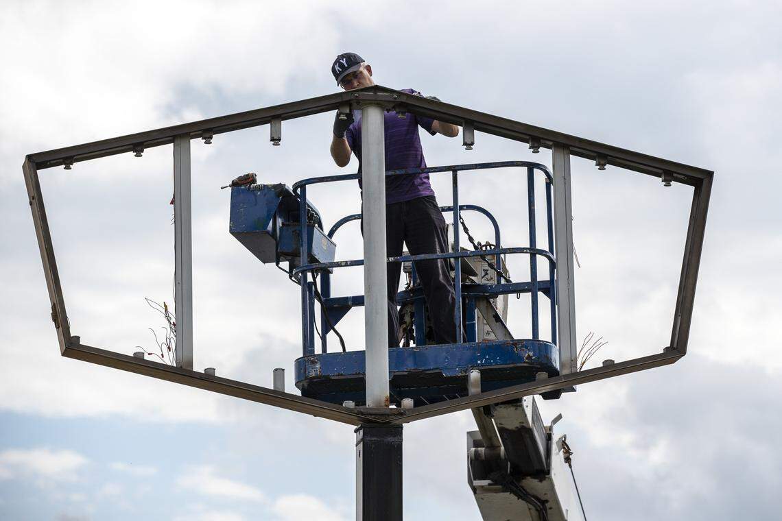 Jonathan Meeksoul, of Image 360, takes down the Denny’s sign Friday at the restaurant’s former location at 1949 Nicholasville Rd.