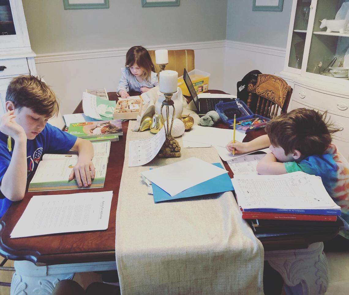 From left, Mac Messer, a fourth grader, Eli Messer, who is in preschool and first grader Robbie Messer, all siblings, study from their Lexington home during the coronavirus school shutdown in March 2020.
