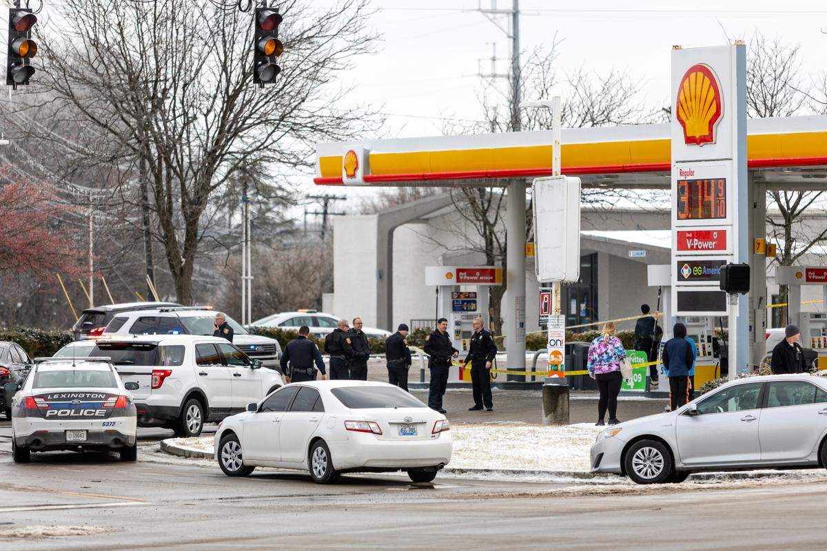 Officers work at a crime scene at a Shell gas station on Newtown Pike in Lexington, Ky., on Saturday, Feb. 5, 2022.