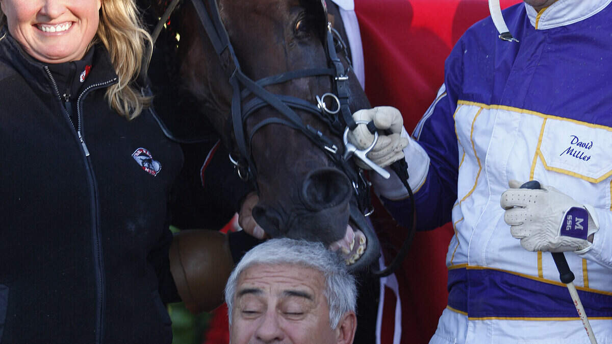 Manofmanymissions, held by Sylvia Hovde and driver David Miller, nibbles on the head of co-owner Mauro Biasuzzi following the colt's victory in the 119th running of the $700,000 Kentucky Futurity at The Red Mile in Lexington, Ky., Sunday, October 2, 2011. Photo by Matt Goins 12730