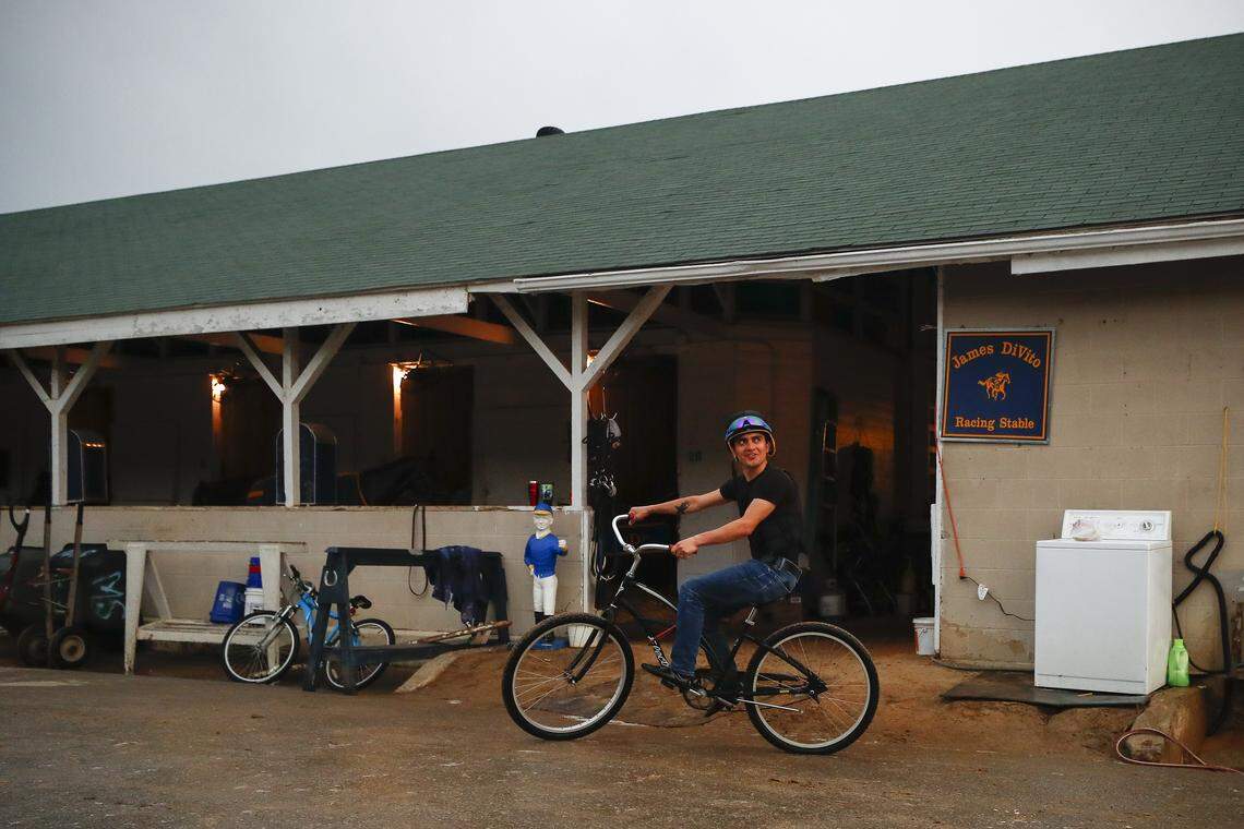 Jockey Miguel Mena rides his bike through the stables before morning workouts at Churchill Downs in Louisville, Ky., Thursday, May 2, 2019.