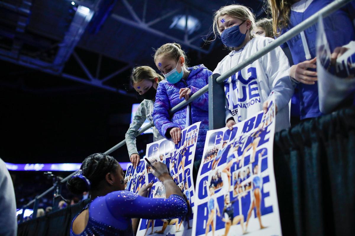 Cally Nixon signs posters for fans during Kentucky’s annual Excite Night meet against Ball State in Rupp Arena on Friday night. The season-opening meet attracted a crowd of 9,226.