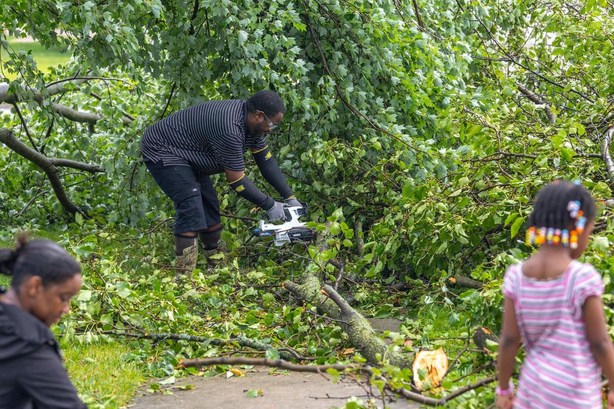 RaShaun West cuts up a tree that fell in front of his home on Sandersville Road in Lexington, Ky., on Thursday, June 26, 2025, following a storm with strong winds.