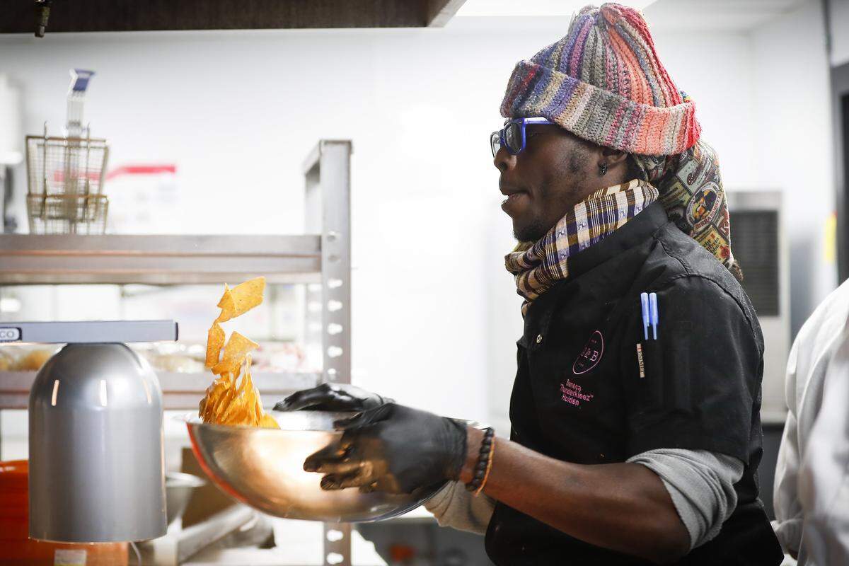 Bazaar Eatery sous chef and co-owner Seneca Holden tosses fresh tortilla chips in the kitchen at Bazaar Eatery located inside Ethereal Brewing Public House in downtown Lexington.