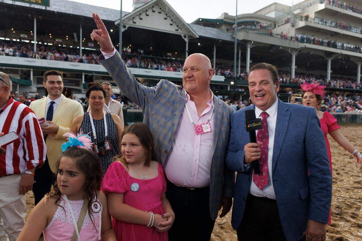 Trainer Kenny McPeek waves to the crowd before being interviewed by NBC’s Kenny Rice after winning the Kentucky Oaks with Thorpedo Anna on Friday. McPeek had never won the race in 14 previous attempts, including three second-place finishes.