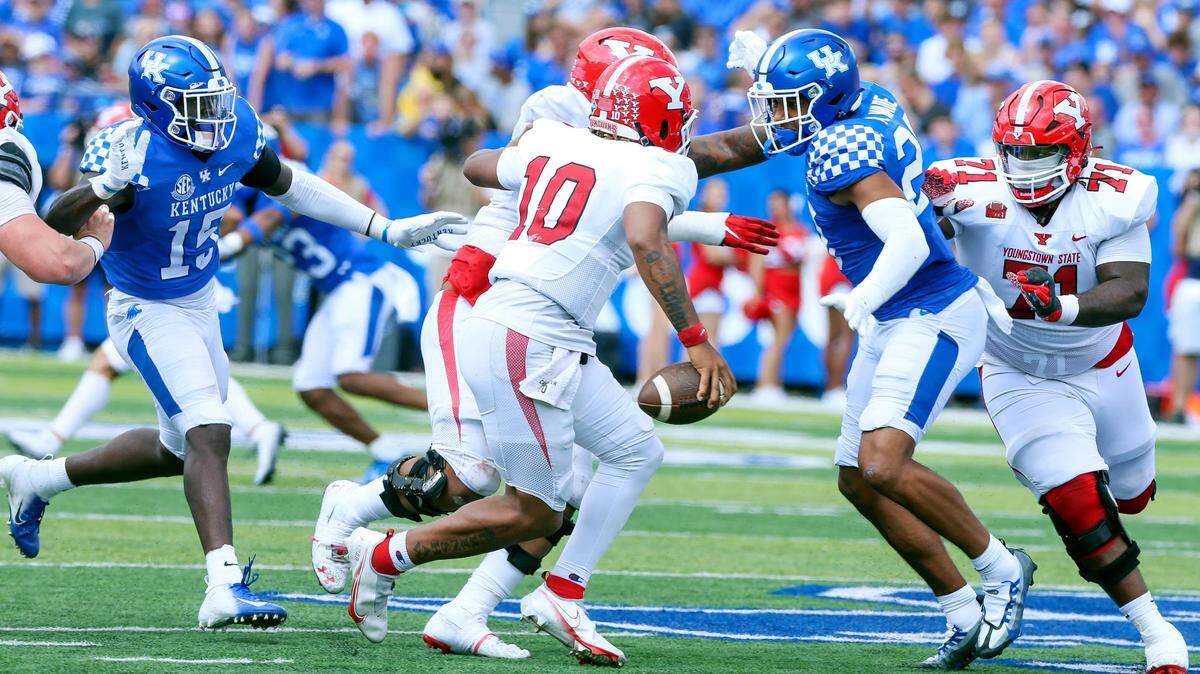 Kentucky’s Keaten Wade, right, and Jordan Wright put pressure on Youngstown State quarterback Demeatric Crenshaw (10) during Saturday’s win at Kroger Field.