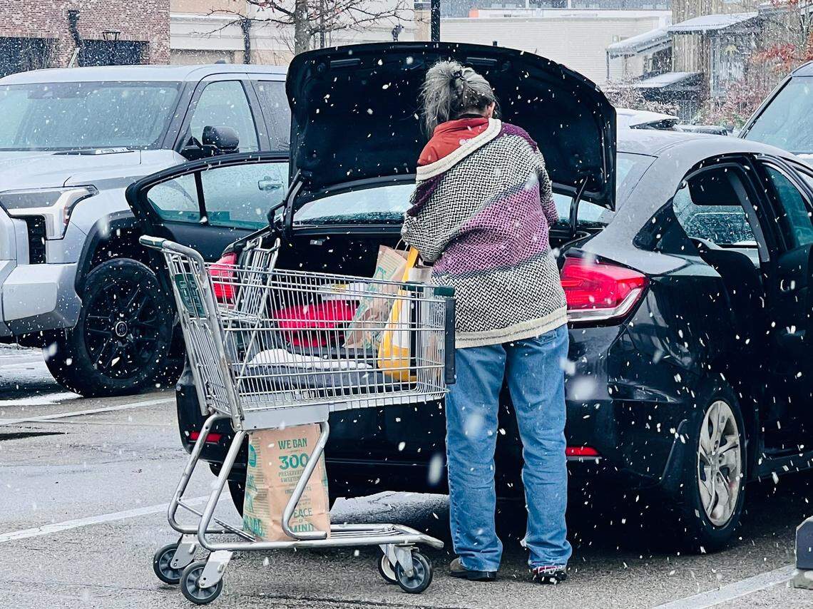 A woman hurriedly loads groceries from Whole Foods Market located at Fritz Farm Dec. 8, 2025, in Lexington, Ky.