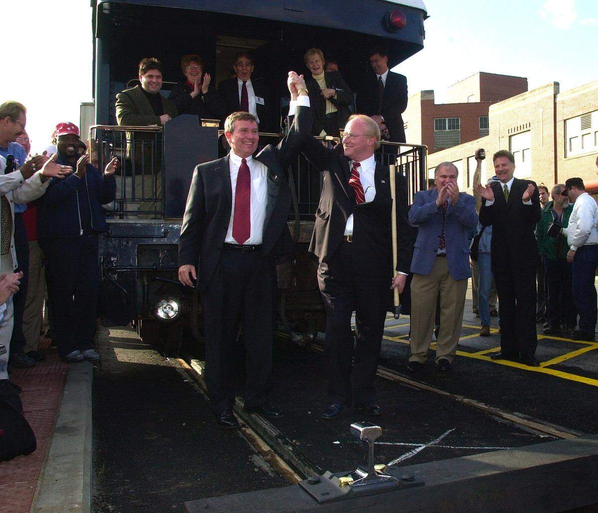 Extension of Amtrak Service to Louisville, Kentucky, Inaugural Trip, Tuesday, December 4, 2001, as Louisville’s Mayor and Jeffersonville, Indiana Mayor ride the train into Louisville’s Union Station. Don Saunders, Amtrak Intercity Acting President and Louisville’s Mayor Dave Armstrong, raise their hands in celebration after driving in the golden spike in todays ceremonies. Just at the right of Armstrong is Jeffersonville, Indiana’s Mayor Tom Gaffigan(blue coat) and next to him is Peter Gilbertson, Anacostia Rail Holdings Chairman.