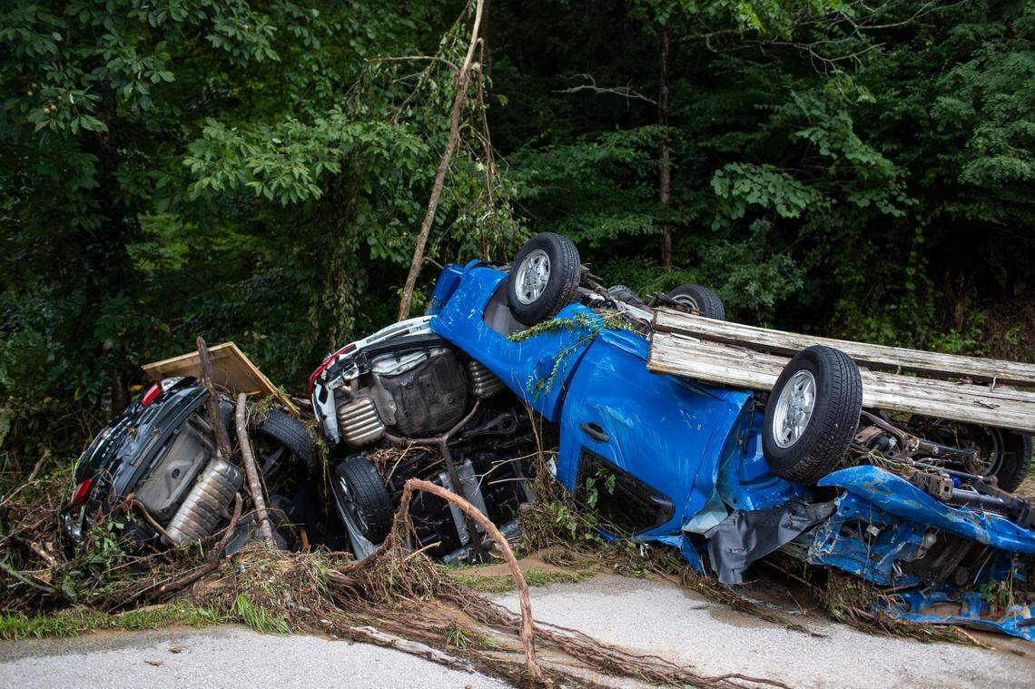 Vehicles are piled up along the side of the road after being carried down street by flooding in Perry County, Ky., Friday, July 29, 2022.