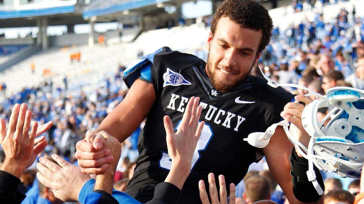 Celebrating Kentucky fans carry wide receiver-turned-quarterback Matt Roark off the field after he led UK to a 10-7 win over Tennessee in the 2011 regular-season finale that snapped a 26-game losing streak for the Wildcats against the Volunteers.