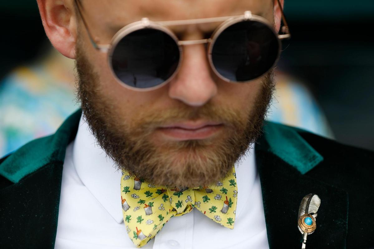 Trevor Schruber wears a yellow tie with a green velour jacket at Churchill Downs in Louisville, Ky., Saturday, May 7, 2022. His wife, Megan, said the green was for “green money day.”