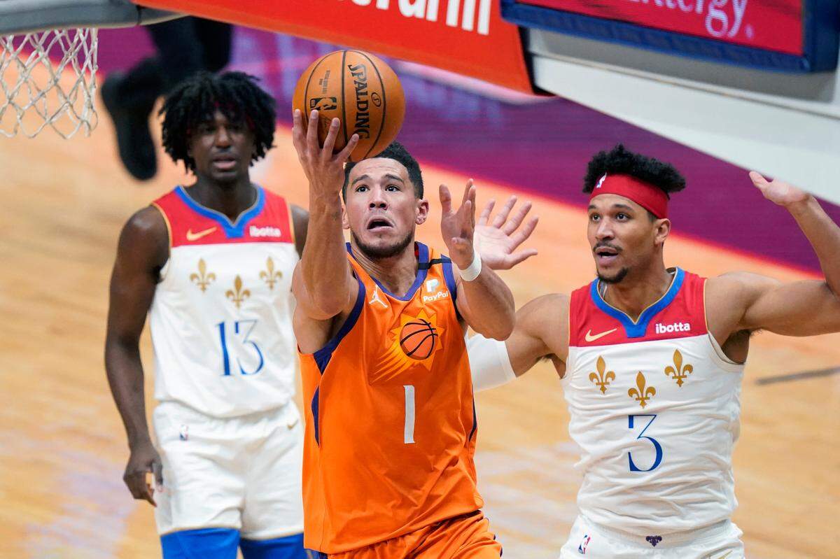 The Suns’ Devin Booker (1) drove to the basket in front of the Pelicans’ Josh Hart (3) and Kira Lewis Jr. (13) on Feb. 19. Phoenix is having its best season of Booker’s career, but the former Kentucky player was not selected to the All-Star Game on Tuesday.