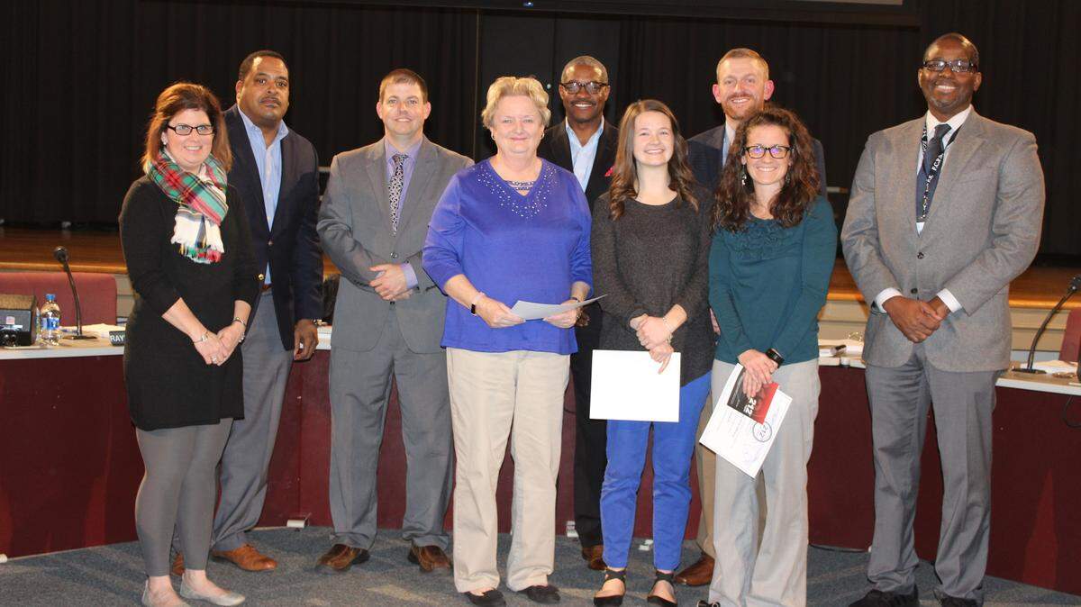 Lexington’s Athens-Chilesburg Elementary School Principal Peggy Henderson, (fourth from left) teacher Haley Hamm, (fifth from left) and behavior interventionist Brooke Kincheloe (sixth from left) were recognized on December 17 by members of the Fayette County Public Schools board and Superintendent Manny Caulk, far right.